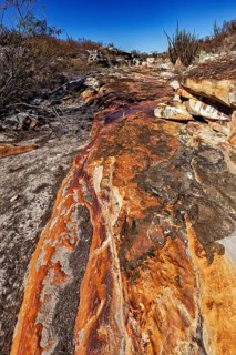 Erosion-shaped rocky landscape in the desert under a blue sky, the thornshrub savanna in the