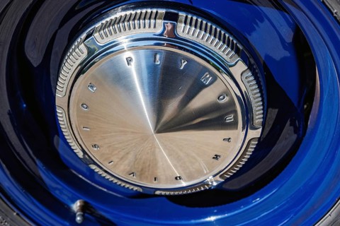 Chrome Plymouth Division hubcap on a blue classic American car at a car meet