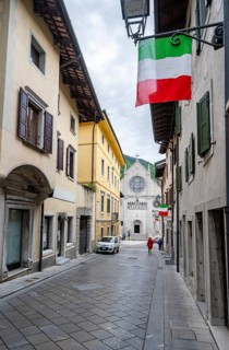 Street with Italian flags, Duomo di Santa Maria Assunta church in the back, Gemona del Friuli,