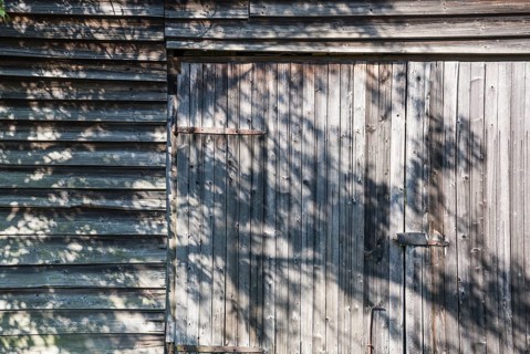 Wooden hut with shadows from trees, Germany