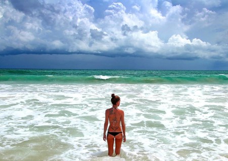 Woman on Phuket beach in bikini, rainy season, Thailand