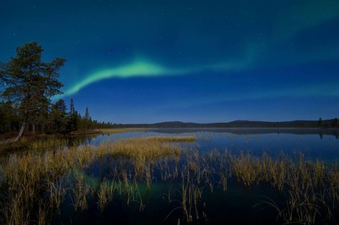The Northern Lights (Aurora borealis) reflected in a lake, Gällivare, Lapland, Sweden