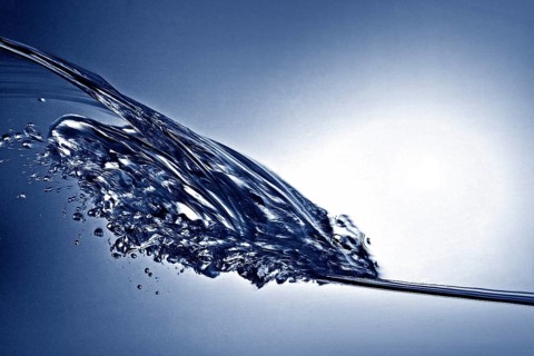 A small longitudinal wave frozen by short exposure in crystal-clear water in the photo studio in