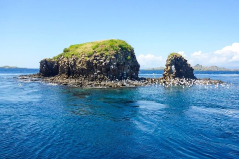 Distinctive rock formation at Batu Bolong dive site means rock with a hole, tourist attraction
