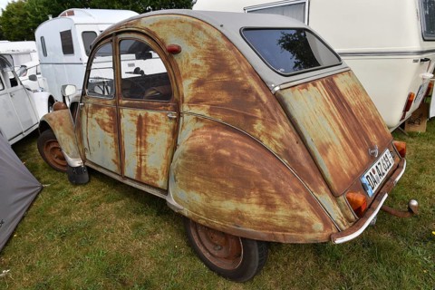 A rusty Citroën 2CV with patina parks on a campsite, vintage Citroën 2CV6 at a duck meeting in