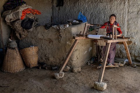 A woman works on her loom, traditional clay house, Choser, Mustang, Upper Mustang, former kingdom,