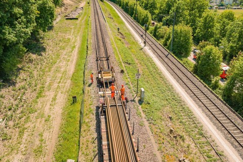 Workers working on a railway line flanked by green landscape, Leonhard Weiss construction site to