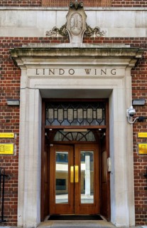 The brown wooden doors and stone surround of the Lindo Wing entrance at St Mary's Hospital mark the