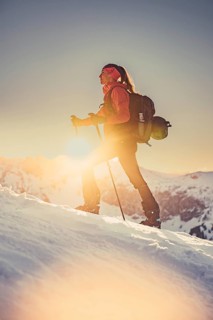 A woman's ski tour at sunrise on the Tegelberg in the Allgäu in the Ammergebirge, Bavaria, Germany