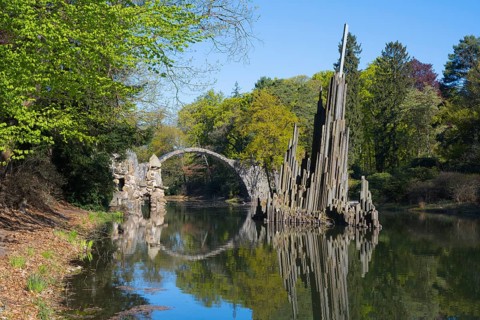 Unique stone bridge and structure reflected in calm water, Rakotzbrücke, Teufelsbrücke, Rakotzsee,
