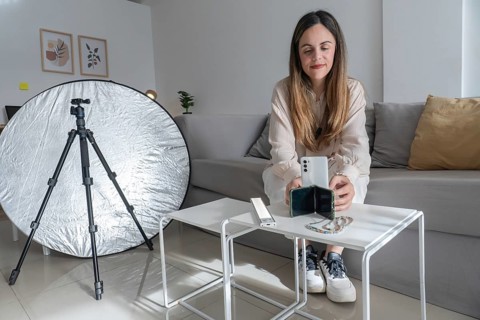 Close up of woman placing smartphone into a small phone stand on coffee table, beaded phone strap