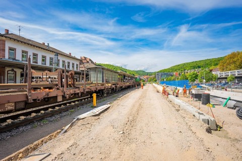 Wide view of construction work next to the tracks at the train station under blue sky, Leonhard