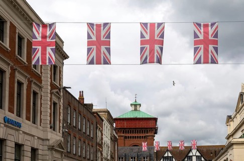 Union Jack bunting flags in a line strung across High Street in town centre of Colchester, Essex,