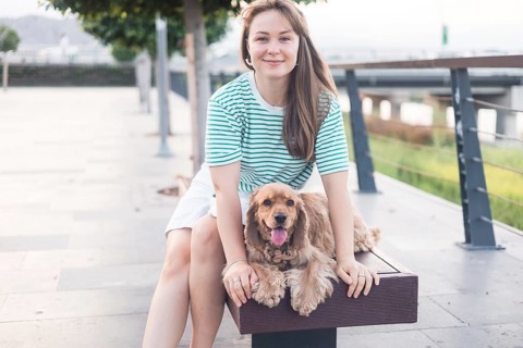 Relaxed moment showcasing companionship between a woman and her dog on a bench