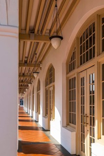 Colonnaded walkway and hanging lanterns line the ground floor gallery of the historic Raffles