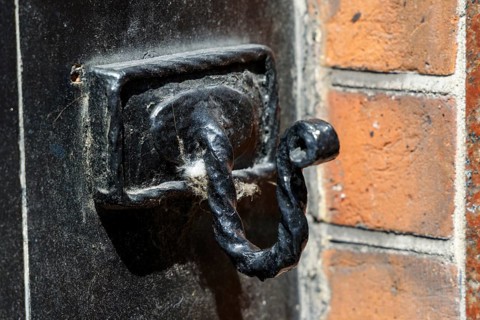 A Victorian cast iron coat hook survives on a former police building in Great Newport Street,