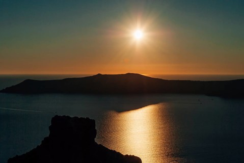 Sunset view over the caldera against the backdrop of the rock of Skaros, Santorini, Greece, The sun