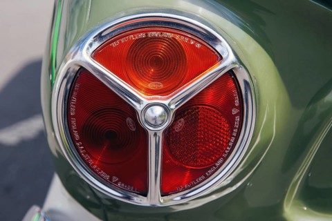 Tri-lobe red tail lamp lens marked Triplex on a green classic car