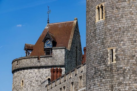A gabled clock stage with a weathervane crowns the medieval Curfew Tower at Windsor Castle, a