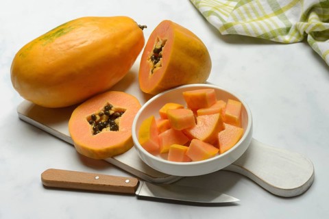 Pawpaw, split fruit in skin, halved and whole fruit, Carica papaya