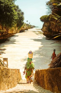 Zanzibar, Tanzania - 20th october, 2025: African women wearing traditional colorful kangas carrying