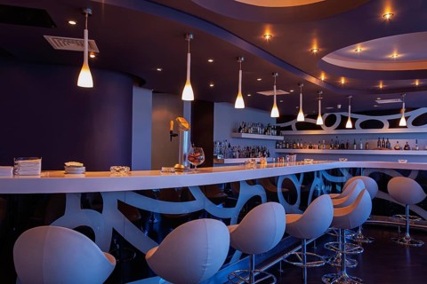 Contemporary bar with stylish lighting and elegant seating in a nighttime setting, Cyprus