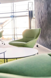 Green armchair against a grey wall in a modern industrial environment