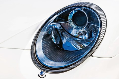 Xenon headlight with carbon-fibre trim ring on a white Porsche sports car