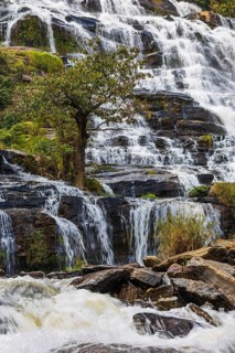 Mae Ya waterfall with cascading flowing water surrounded by lush tropical vegetation, near Doi