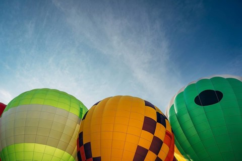 Colorful hot air balloons against blue sky at outdoor festival, Vibrant hot air balloons with