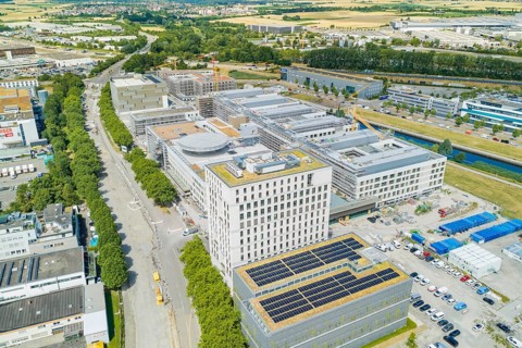 View of a densely built industrial area with modern buildings and solar systems, new hospital