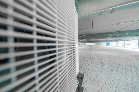 Industrial elements in a parking garage, focus on ventilation grilles, shades of grey, car park