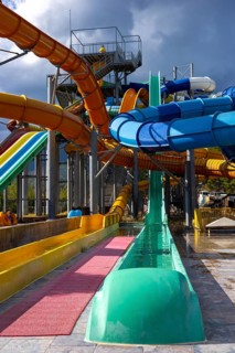 Families and friends experience excitement at a water park in Turkiye. Colorful slides twist and