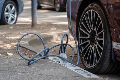 An e-car is charged with a cable at a charging curb on the KÖ, Düsseldorf, Germany
