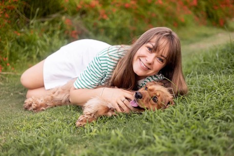Serene connection between woman and dog in a lush grassy setting