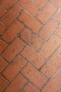 The flooring consists of a herringbone pattern made from red bricks, showing varying textures and