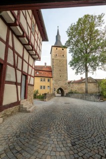 20 August 2026, View of the historic town gate and half-timbered house along a cobblestone street