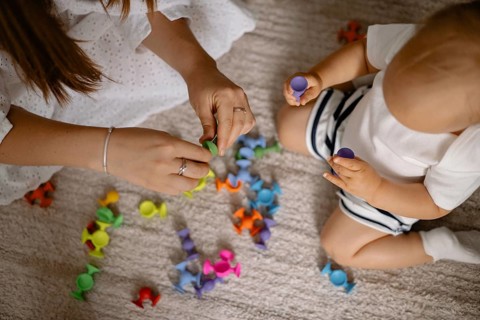 A mother and child play with colorful toys together, sharing a moment of joy and interaction