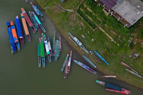 Aerial view, colorful Laotian boats lying on the banks of the Nam Ou River and in the water, Muang