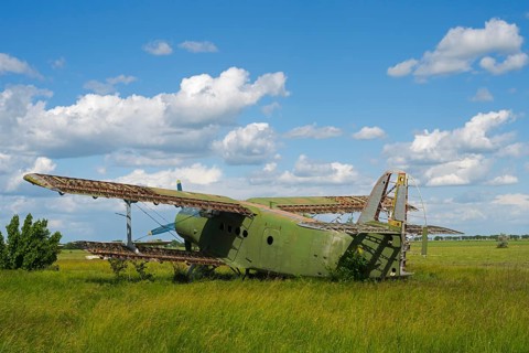 Green aircraft wreck on high meadow under a beautiful blue sky, Antonov An-2 multi-purpose