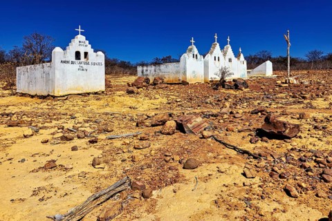 Abandoned church in a dry desert landscape under a clear blue sky, cemetery in the spiny savanna of