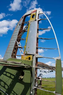 Close-up of aircraft wreck with metal structure and blue sky in the background, Antonov An-2