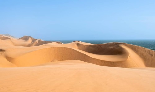Sand dunes and sea, dune sea, impressive desert landscape, Sandwich Harbour, Namib Naukluft Park,