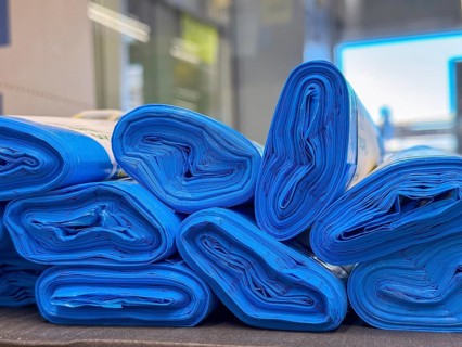 Rolled blue mats stacked neatly. The mats are made of durable material, suitable for various