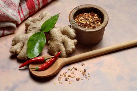 Ginger, ginger root with kaffir lime leaf and chili pepper and chilli flakes in pot