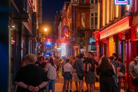 A vivid night view of a street full of people and illuminated shops, nightlife, Dublin, Ireland