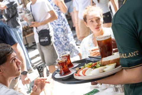 Istanbul, Turkey. August 7th 2026. A restaurant waiter serves tourists a traditional Turkish