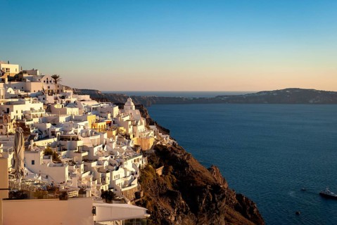 Fira in the rays of the setting sun. Santorini, Greece, A scenic view of Santorini with white