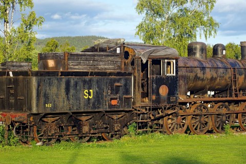 Old, rusty steam locomotive on rails in rural area with trees, Inlandsbanan, Inlandsbahn, Sweden