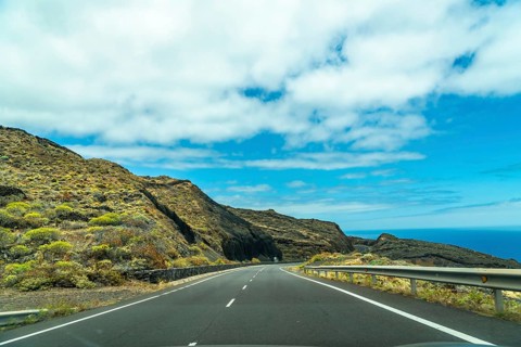 Road tripping along a coastal highway in el hierro, canary islands, showing a winding asphalt road